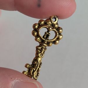 Antique gold skeleton key jewelry charm, extremely detailed design